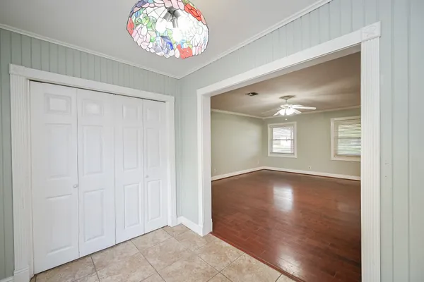 an empty room with wooden floor and a ceiling fan