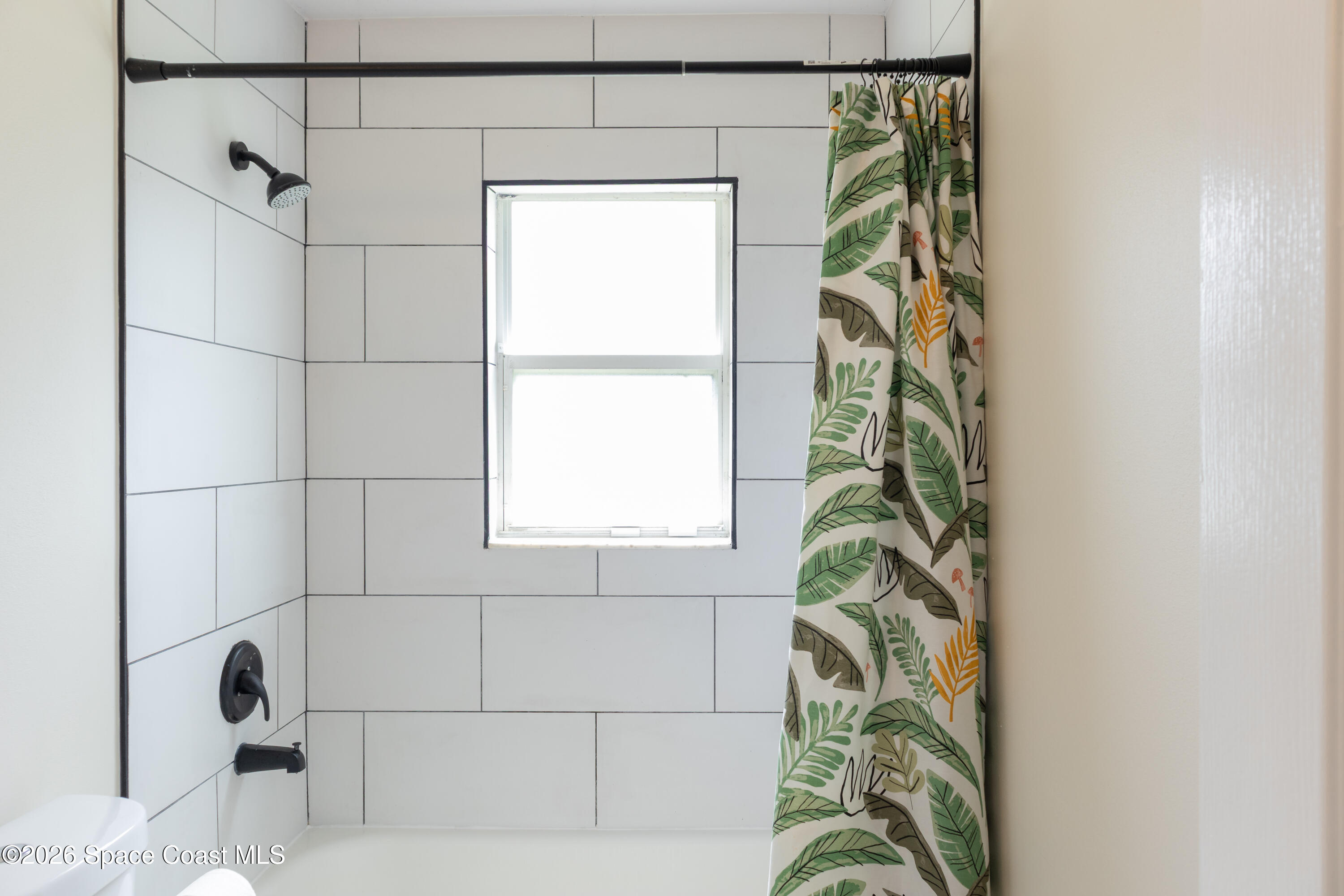 1572 Holbrook Road Northwest Palm Bay, FL 32907 - Photo 16 of 38 a bath room with a window and a shower curtain