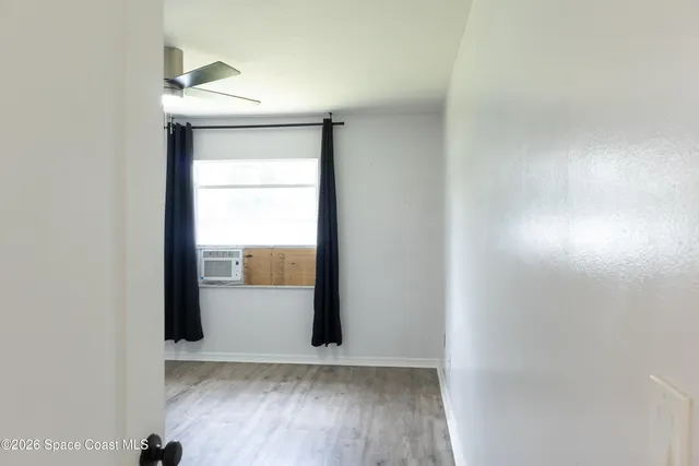 an empty room with wooden floor and mirror