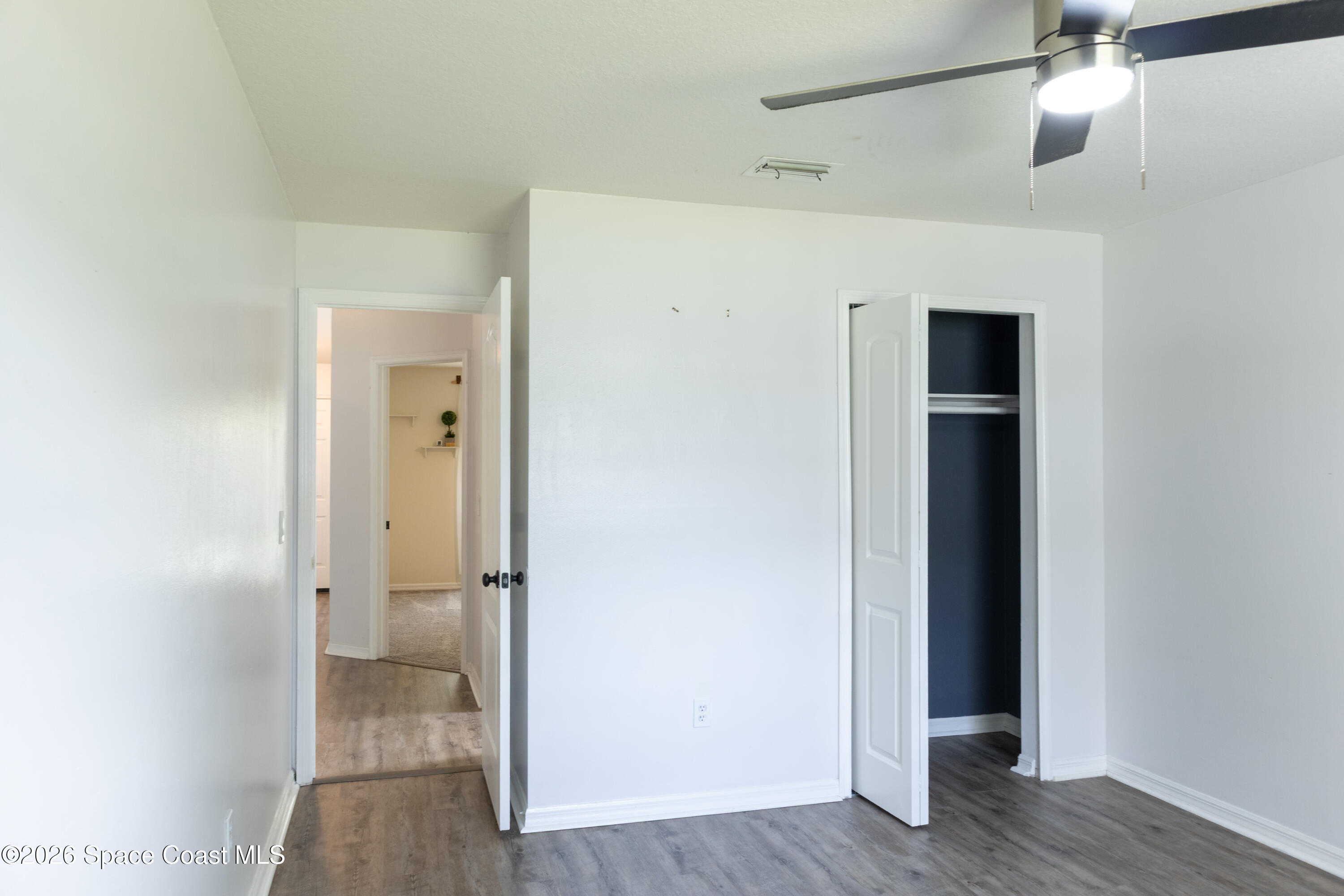 1572 Holbrook Road Northwest Palm Bay, FL 32907 - Photo 20 of 38 an empty room with wooden floor and mirror