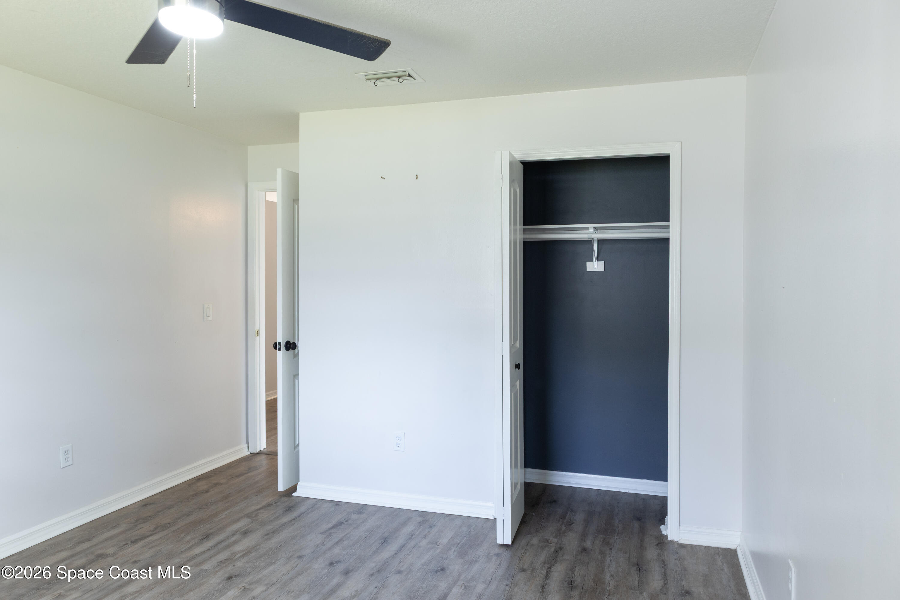 1572 Holbrook Road Northwest Palm Bay, FL 32907 - Photo 21 of 38 an empty room with wooden floor and closet