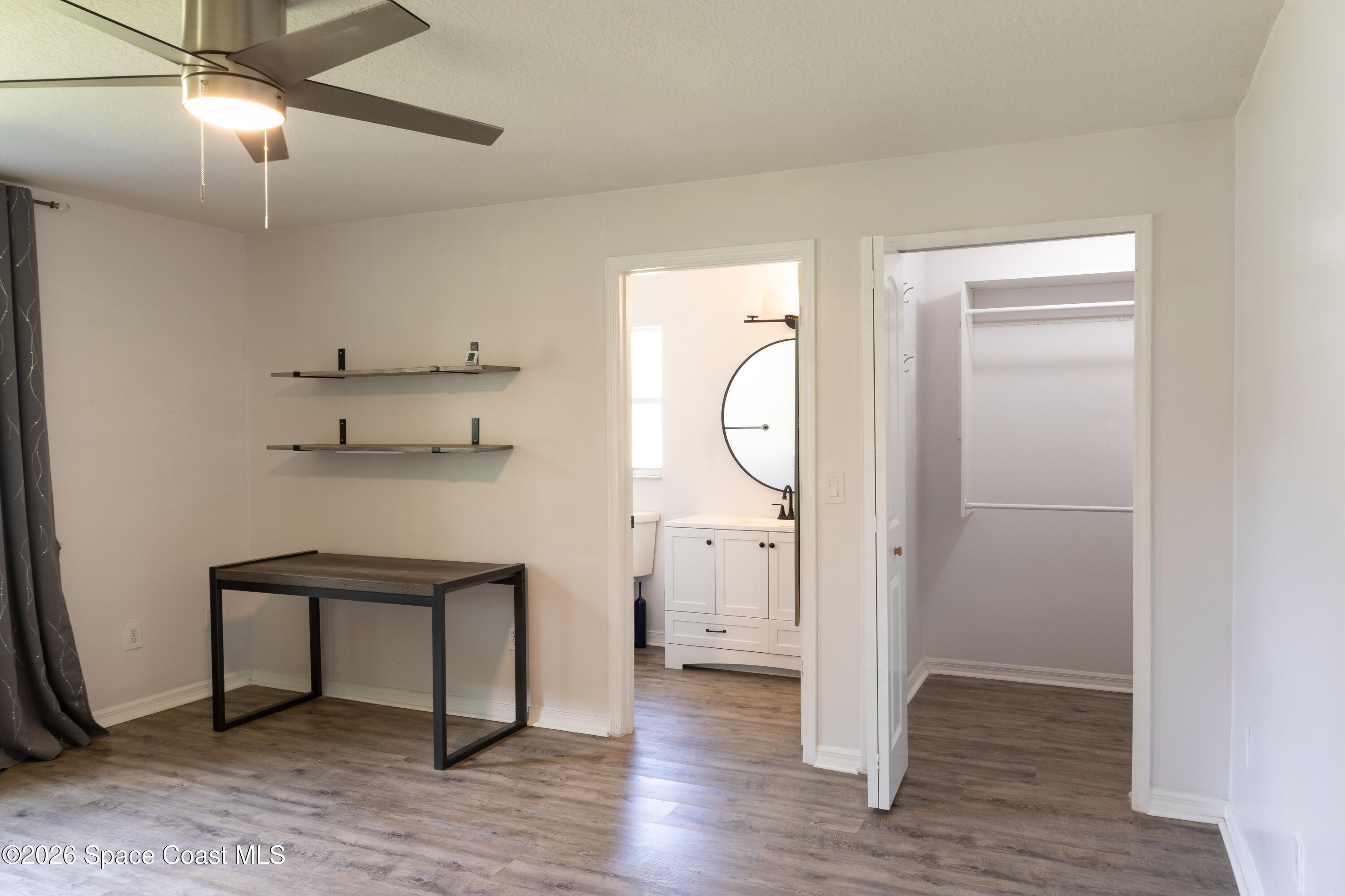 1572 Holbrook Road Northwest Palm Bay, FL 32907 - Photo 30 of 38 a view of empty room with wooden floor and fan