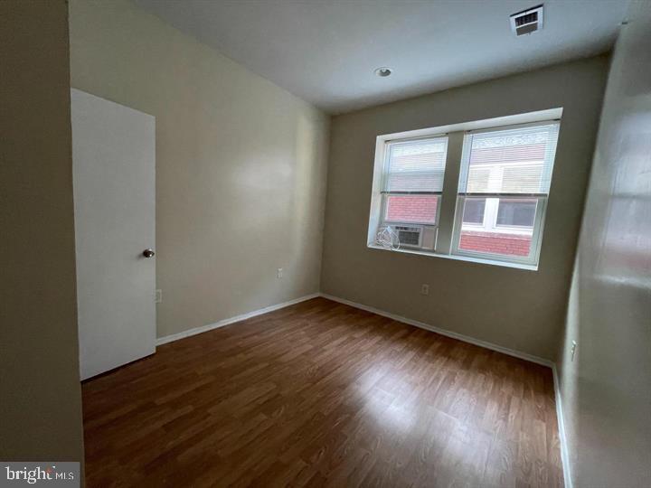 4726 Chestnut Street, Unit 8 Philadelphia, PA 19139 - Photo 4 of 9 an empty room with wooden floor and windows