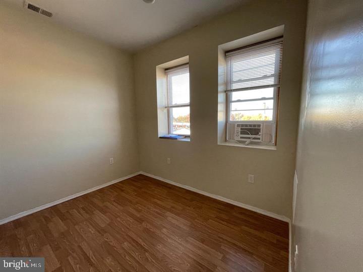4726 Chestnut Street, Unit 8 Philadelphia, PA 19139 - Photo 5 of 9 an empty room with wooden floor and windows