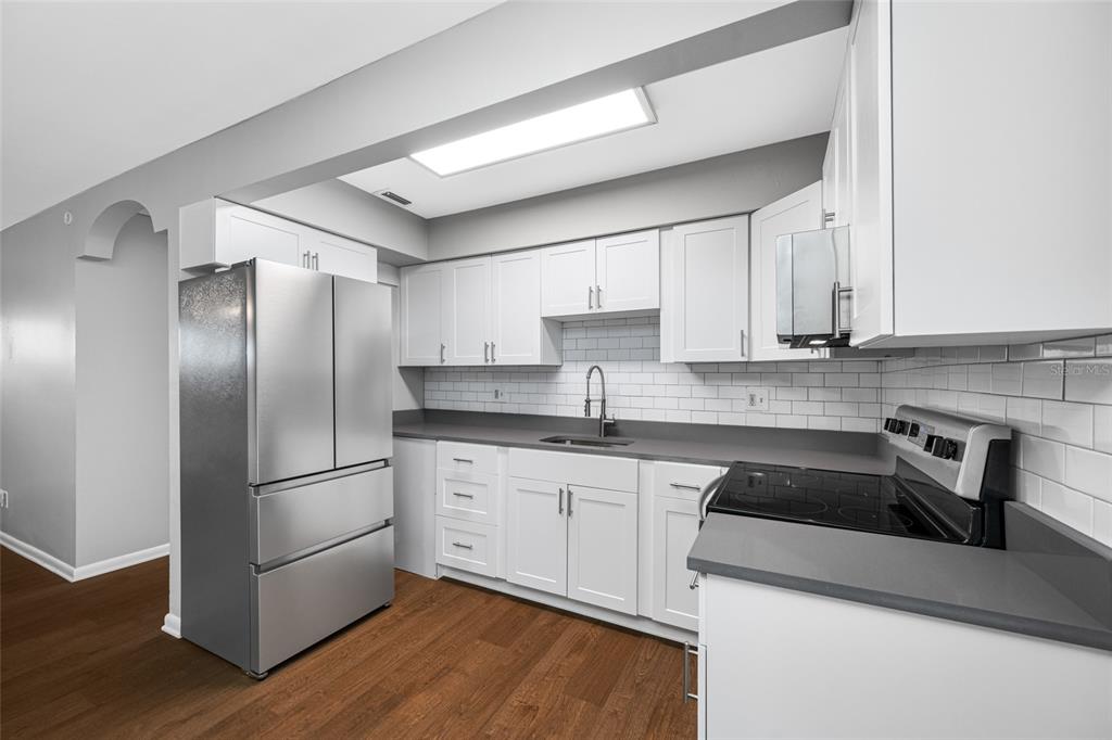 3602 South MacDill Avenue, Unit 1 Tampa, FL 33629 - Photo 2 of 18 a kitchen with stainless steel appliances granite countertop a refrigerator a sink and white cabinets