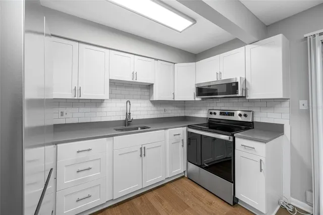 a kitchen with stainless steel appliances granite countertop a sink a stove a microwave and cabinets