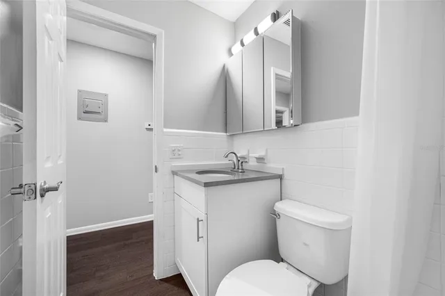 a bathroom with a granite countertop toilet sink and mirror