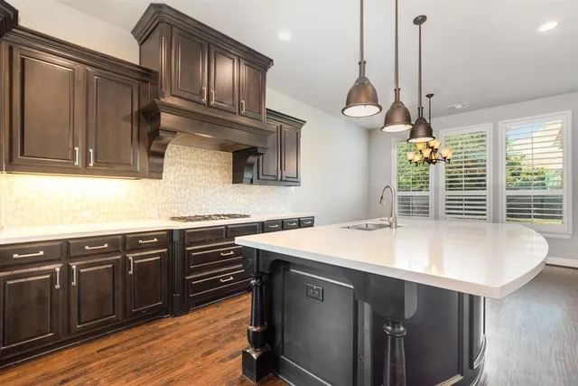 a kitchen with stainless steel appliances granite countertop a sink a microwave cabinets and a wooden floor