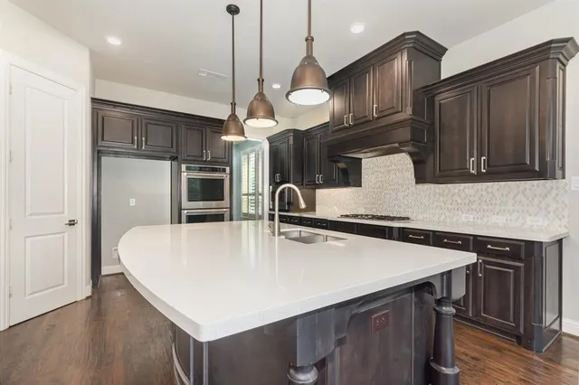 a kitchen with cabinets appliances and a wooden floor
