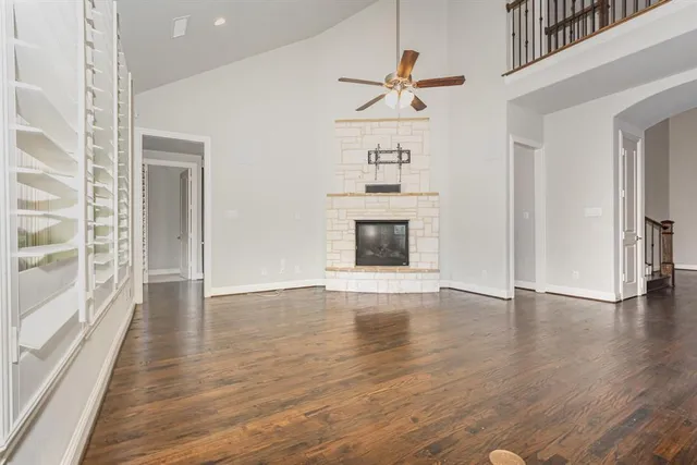 a view of empty room with wooden floor and fireplace