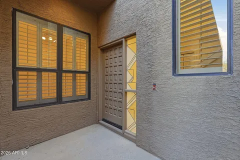 a pathway with a house next to a brick wall