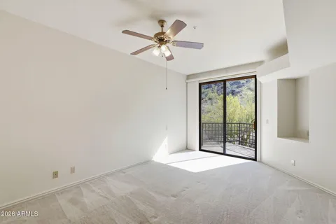 a view of an empty room with chandelier fan