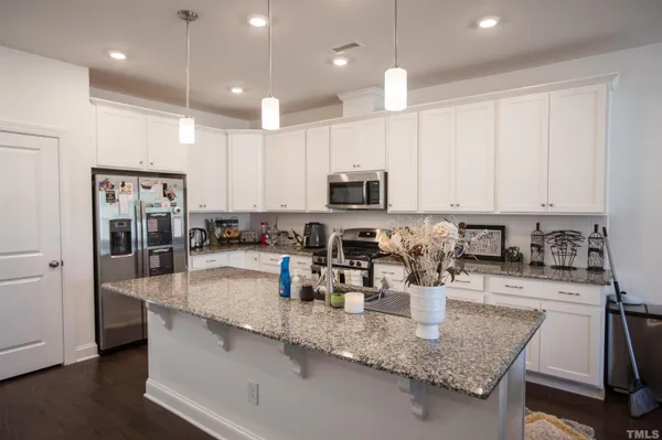 a kitchen with granite countertop a sink stove and cabinets