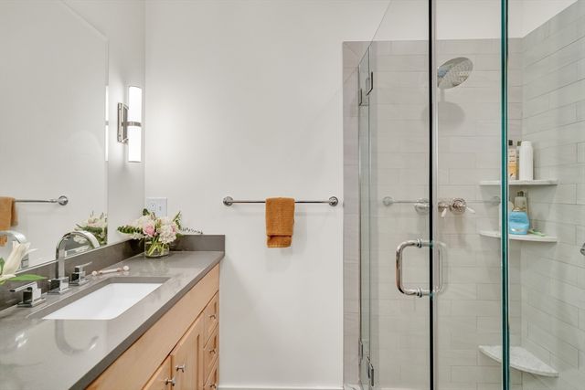 a bathroom with a granite countertop shower sink and mirror