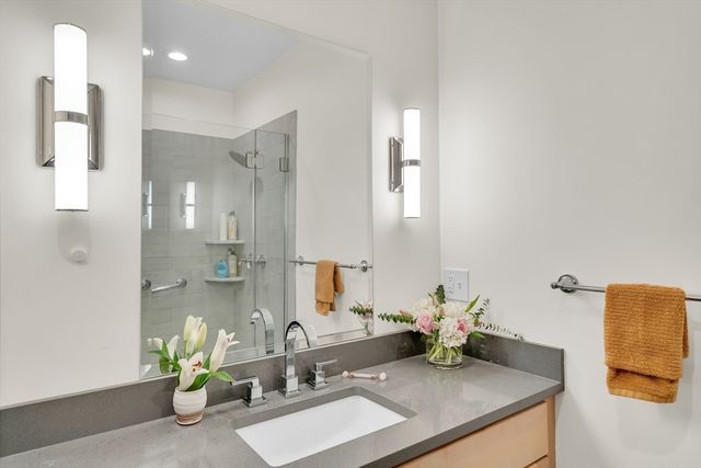 a bathroom with a sink a mirror and a shower