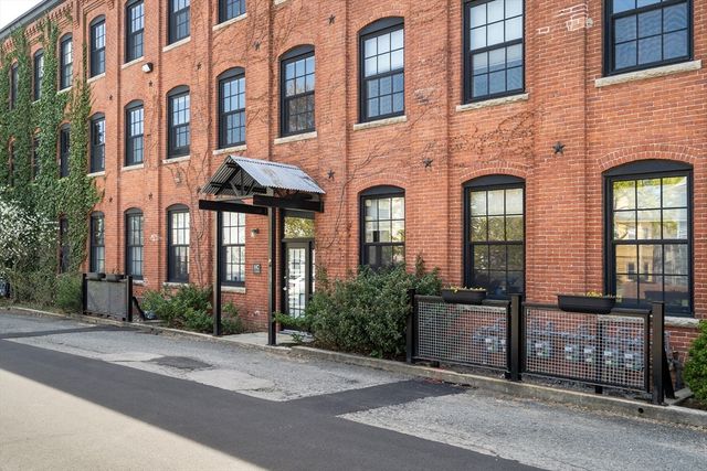 a front view of a house with a garden and plants