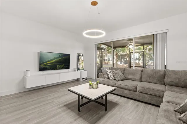 a living room with furniture a flat screen tv and a large window