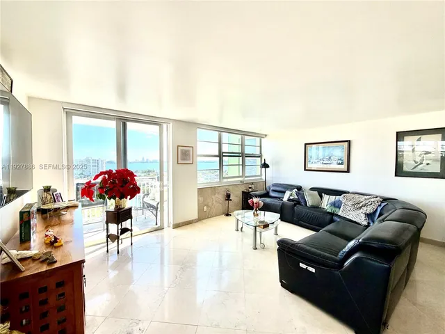 a living room with furniture a chandelier and a large window