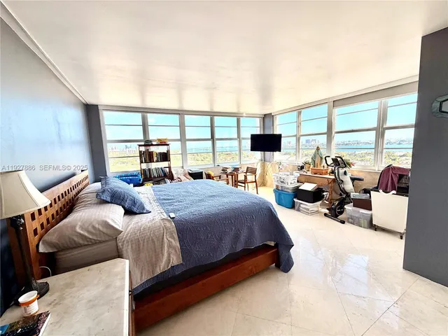 a large bedroom with a bed and large windows