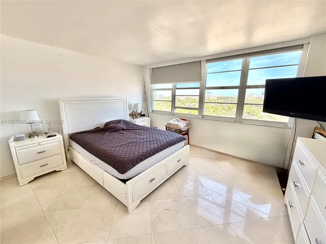 a spacious bedroom with a bed and a large window