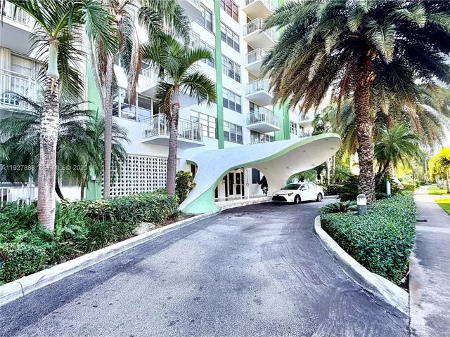 a view of a house with a yard and potted plants