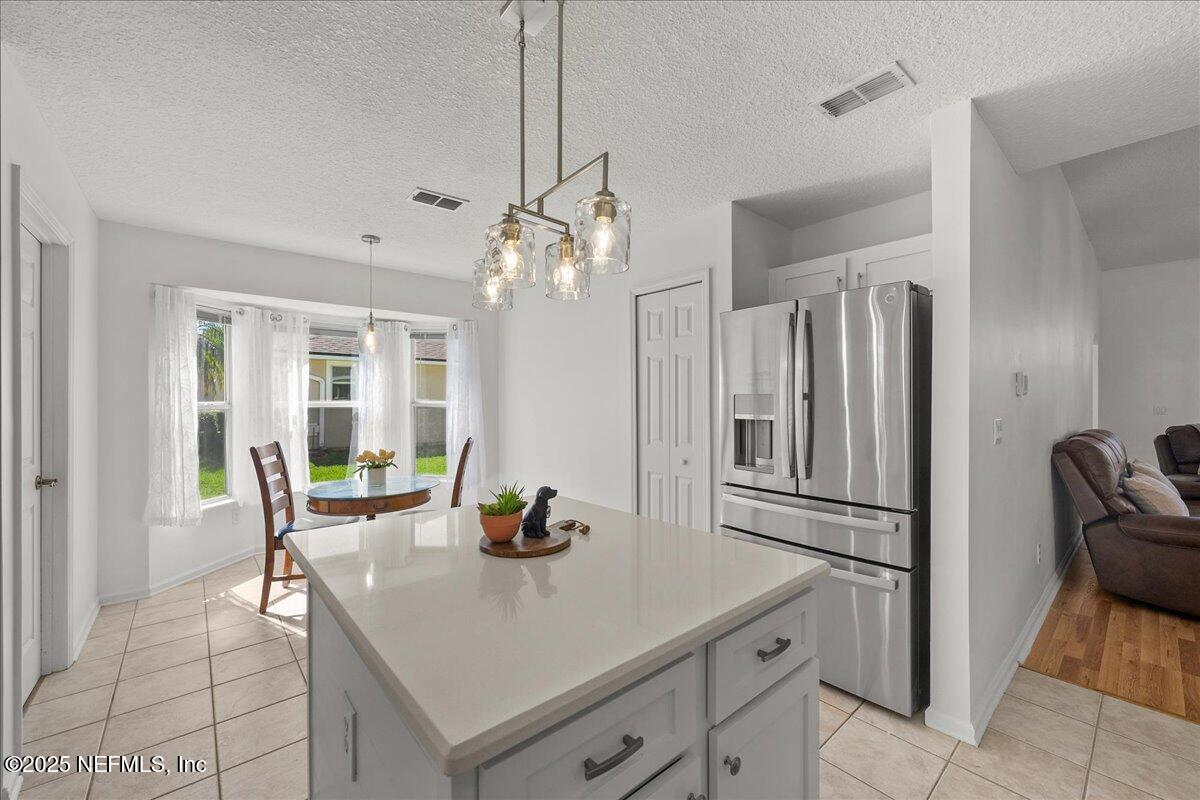 1940 Bluebonnet Way Fleming Island, FL 32003 - Photo 11 of 44 a kitchen with stainless steel appliances granite countertop a dining table chairs and chandelier