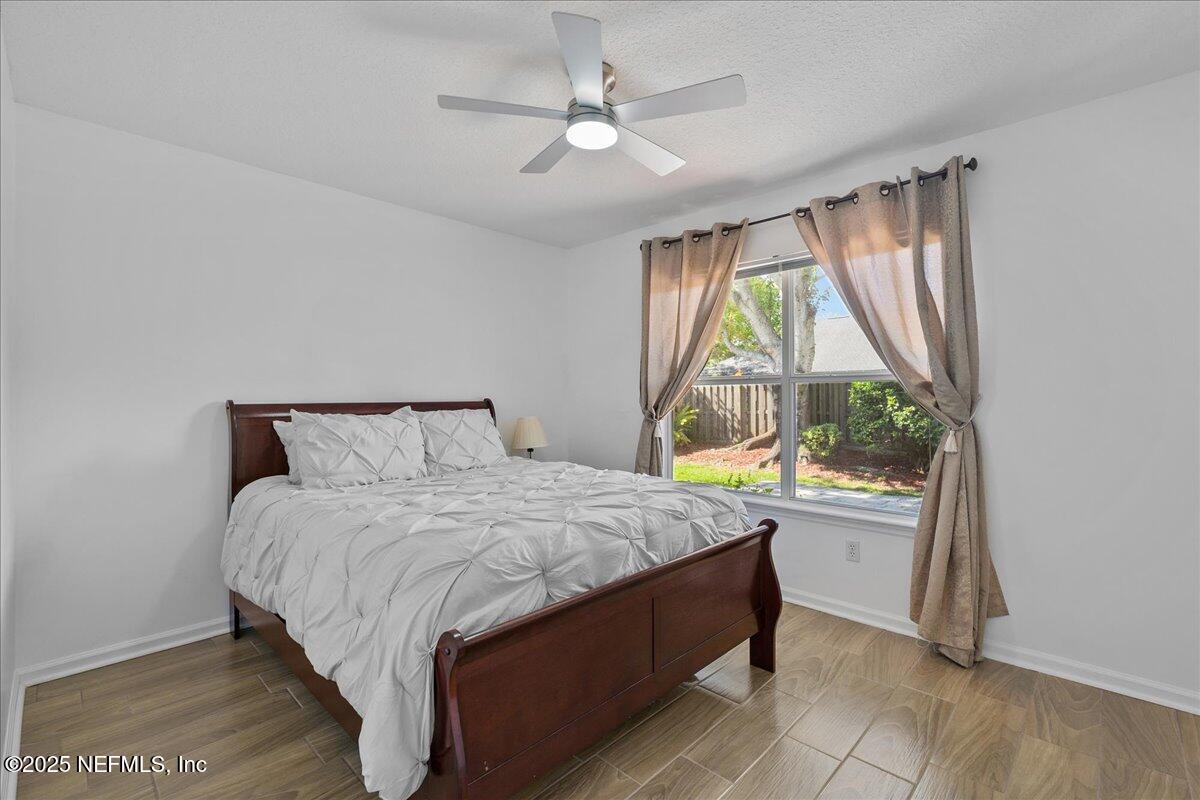 1940 Bluebonnet Way Fleming Island, FL 32003 - Photo 17 of 44 a bedroom with a bed and a large window with outer view