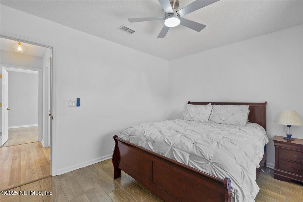 1940 Bluebonnet Way Fleming Island, FL 32003 - Photo 18 of 44 a bedroom with a bed and a ceiling fan