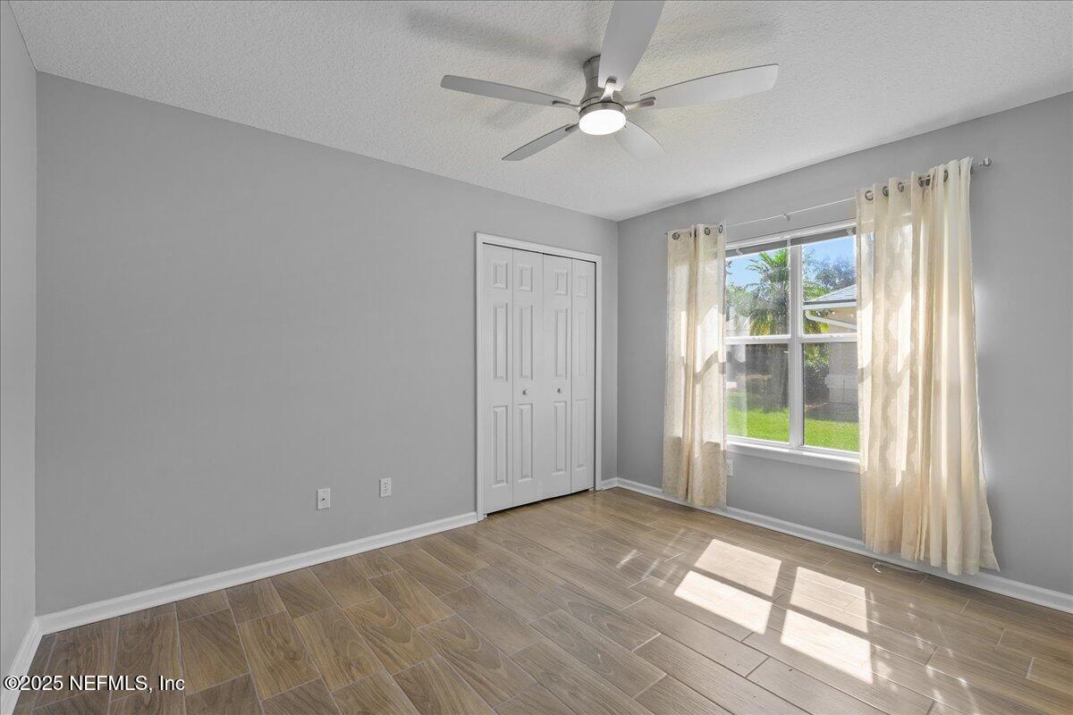 1940 Bluebonnet Way Fleming Island, FL 32003 - Photo 20 of 44 an empty room with windows and ceiling fan