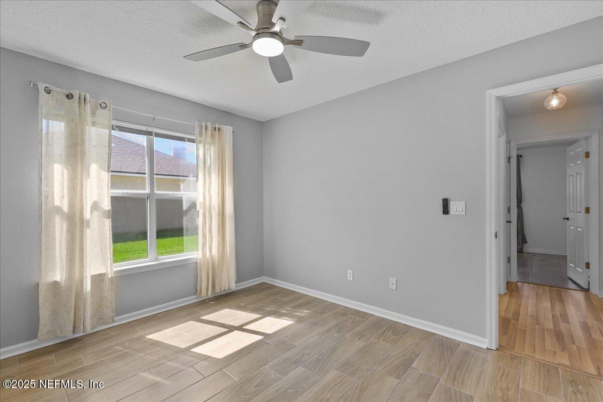 1940 Bluebonnet Way Fleming Island, FL 32003 - Photo 21 of 44 wooden floor in an empty room with a window