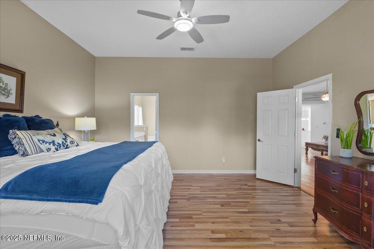 1940 Bluebonnet Way Fleming Island, FL 32003 - Photo 23 of 44 a bedroom with a bed and a chandelier