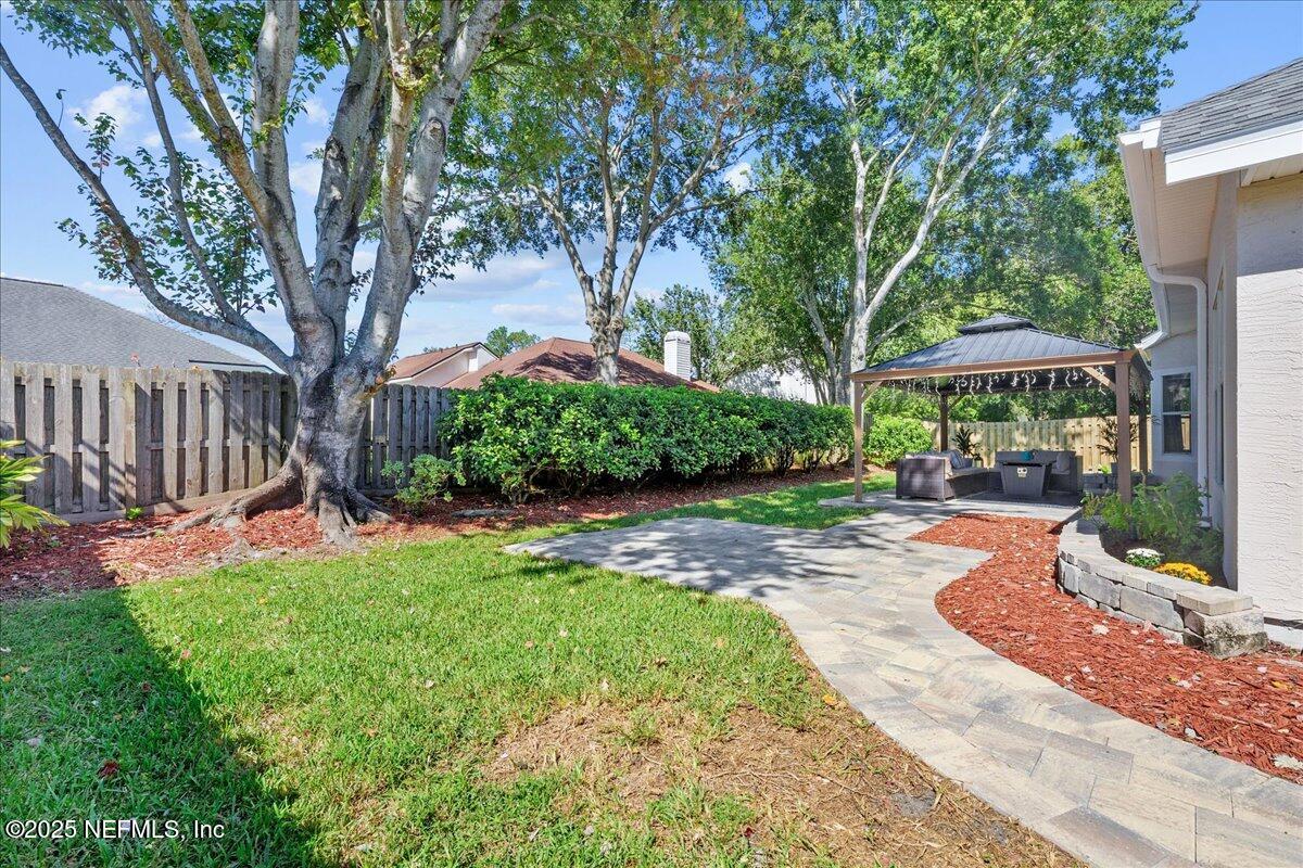 1940 Bluebonnet Way Fleming Island, FL 32003 - Photo 29 of 44 a view of a patio with a table and chairs under an umbrella
