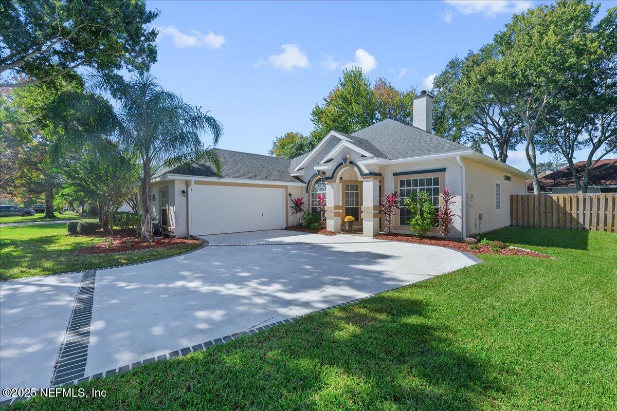 1940 Bluebonnet Way Fleming Island, FL 32003 - Photo 3 of 44 a view of a yard in front of a house with plants and large tree