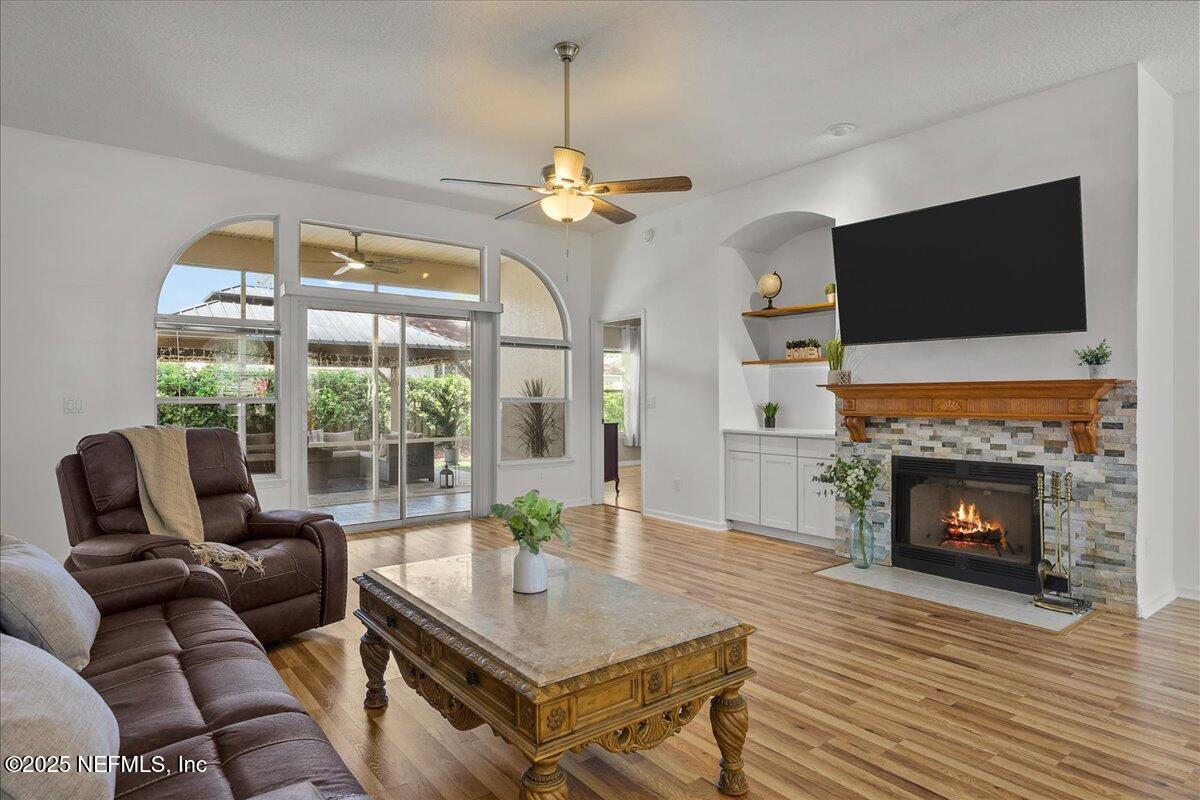 1940 Bluebonnet Way Fleming Island, FL 32003 - Photo 9 of 44 a living room with furniture a fireplace and a flat screen tv