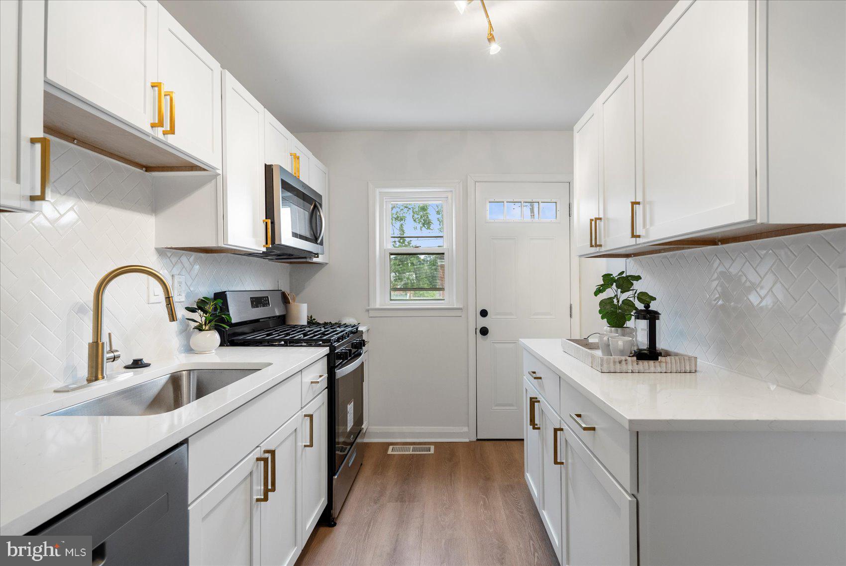2210 Walshire Avenue Baltimore, MD 21214 - Photo 15 of 42 a kitchen with stainless steel appliances granite countertop a sink stove refrigerator and cabinets