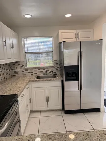 a kitchen with a refrigerator sink and cabinets