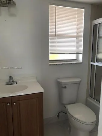 a bathroom with a toilet sink and a window