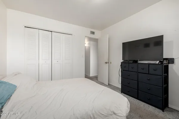 a bedroom with a bed and a flat screen tv