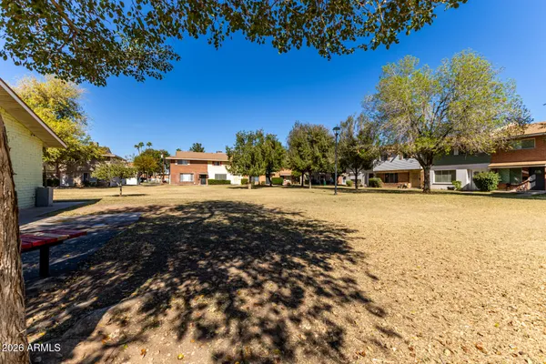 a view of yard with houses and trees in the background