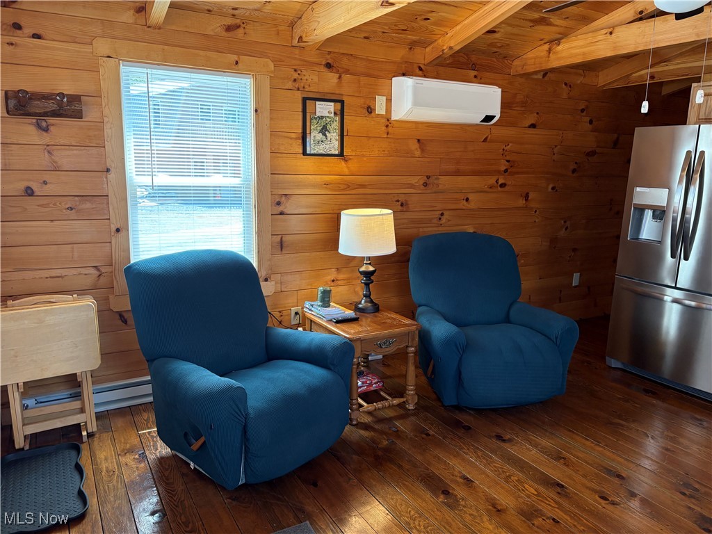 5919 Lake Road West, Unit 18 Ashtabula, OH 44004 - Photo 12 of 32 Living area featuring hardwood / wood-style floors, wooden walls, a wooden ceiling with exposed beams, baseboard heating, and a wall unit AC