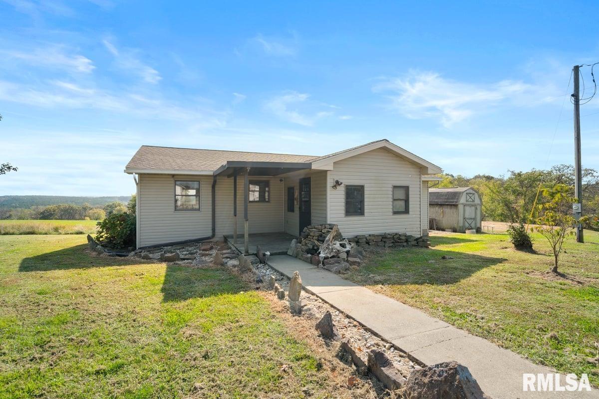 a view of a house with a yard and sitting area