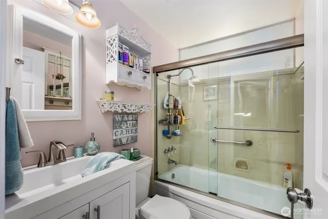 a bathroom with a bathtub shower sink mirror and toilet