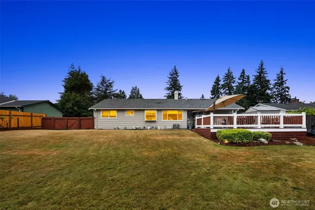 a front view of a house with a yard and potted plants
