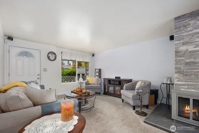 a living room with furniture fireplace and a large window