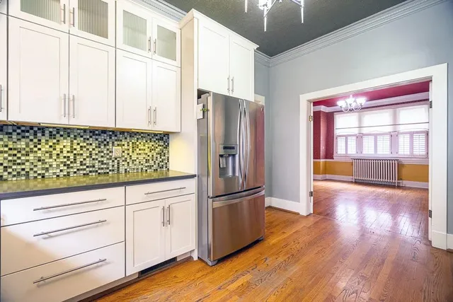 a kitchen with granite countertop white cabinets and stainless steel appliances