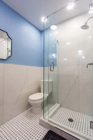 a bathroom with a sink a toilet and shower