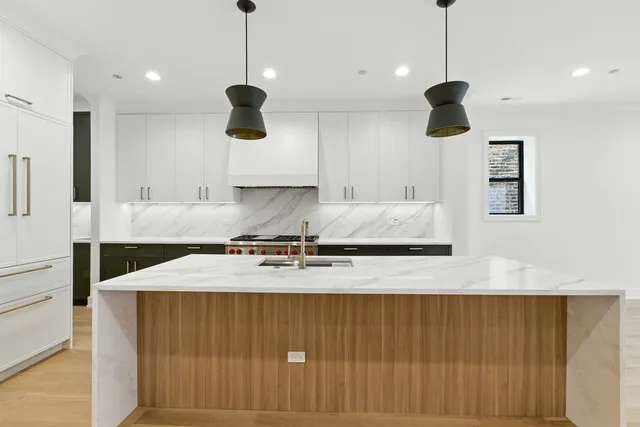 a kitchen with kitchen island a counter space a sink and a refrigerator