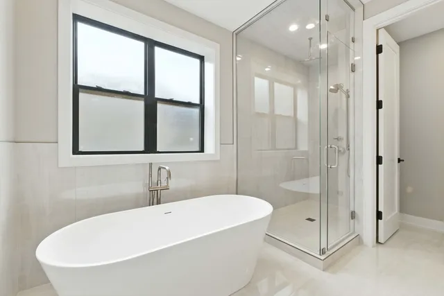 a white bath tub sitting next to a shower
