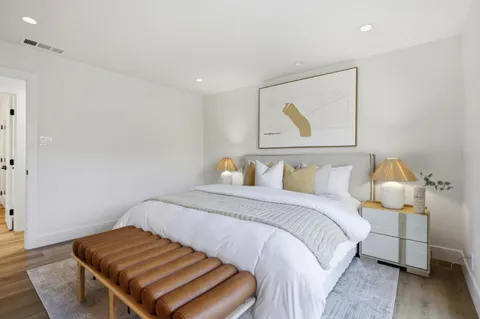 a bedroom with a bed and wooden floor