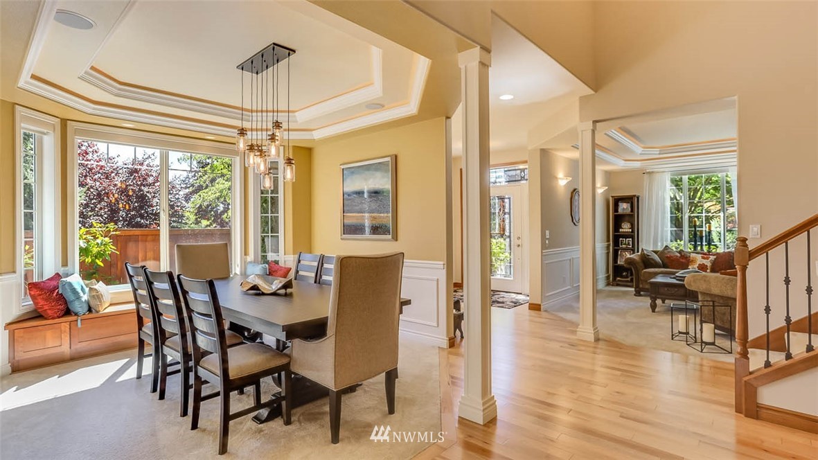 21131 37th Avenue Southeast Bothell, WA 98021 - Photo 12 of 40 a dining room with wooden floor a chandelier a glass table and chairs